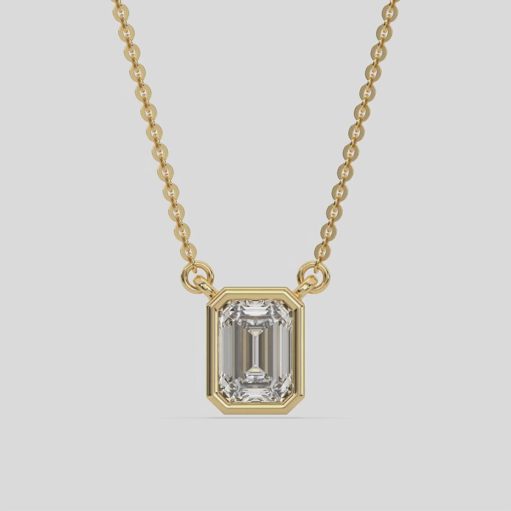 This yellow gold Emerald Solitaire Diamond Necklace made with an emerald cut diamond in bezel setting with adjustable chain 