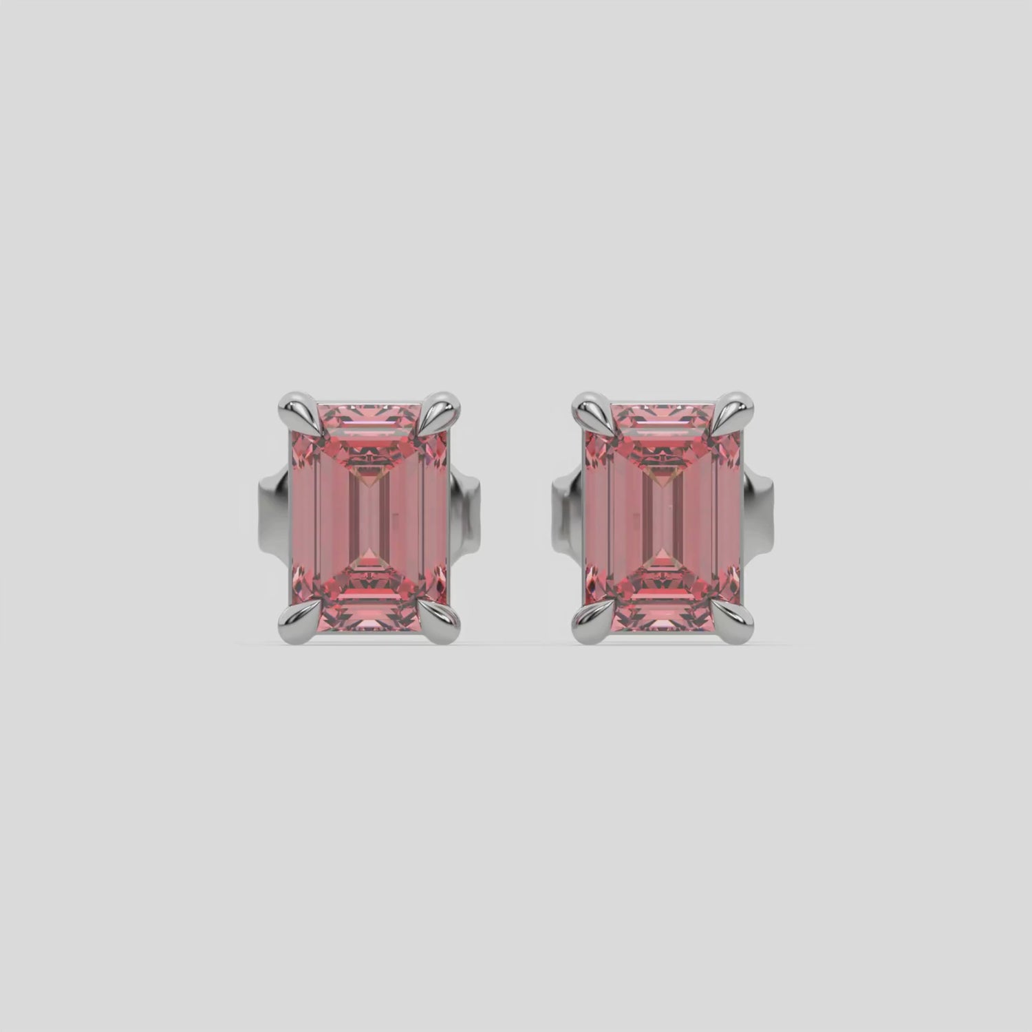 This video features a white gold Classic Emerald Diamond Earrings made with an fancy pink emerald-cut diamonds set in a four prong setting