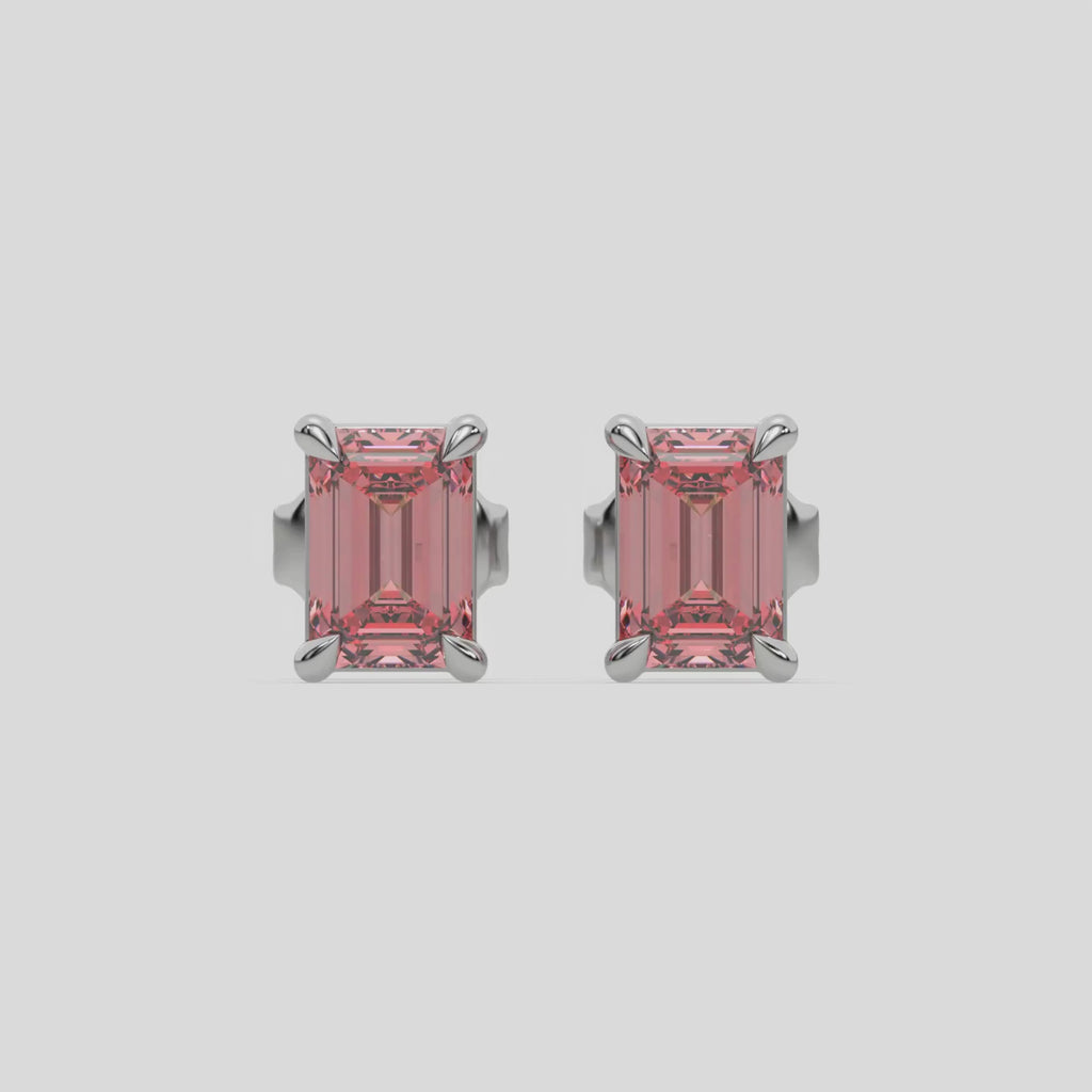 This video features a white gold Classic Emerald Diamond Earrings made with an fancy pink emerald-cut diamonds set in a four prong setting