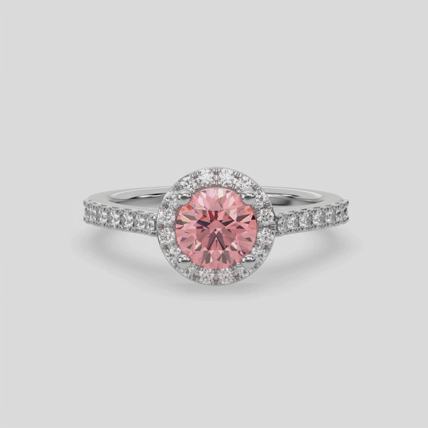 This video features a white gold Round Diamond Halo Engagement Ring is made with a fancy Pink round solitaire diamond set in a four-prong setting