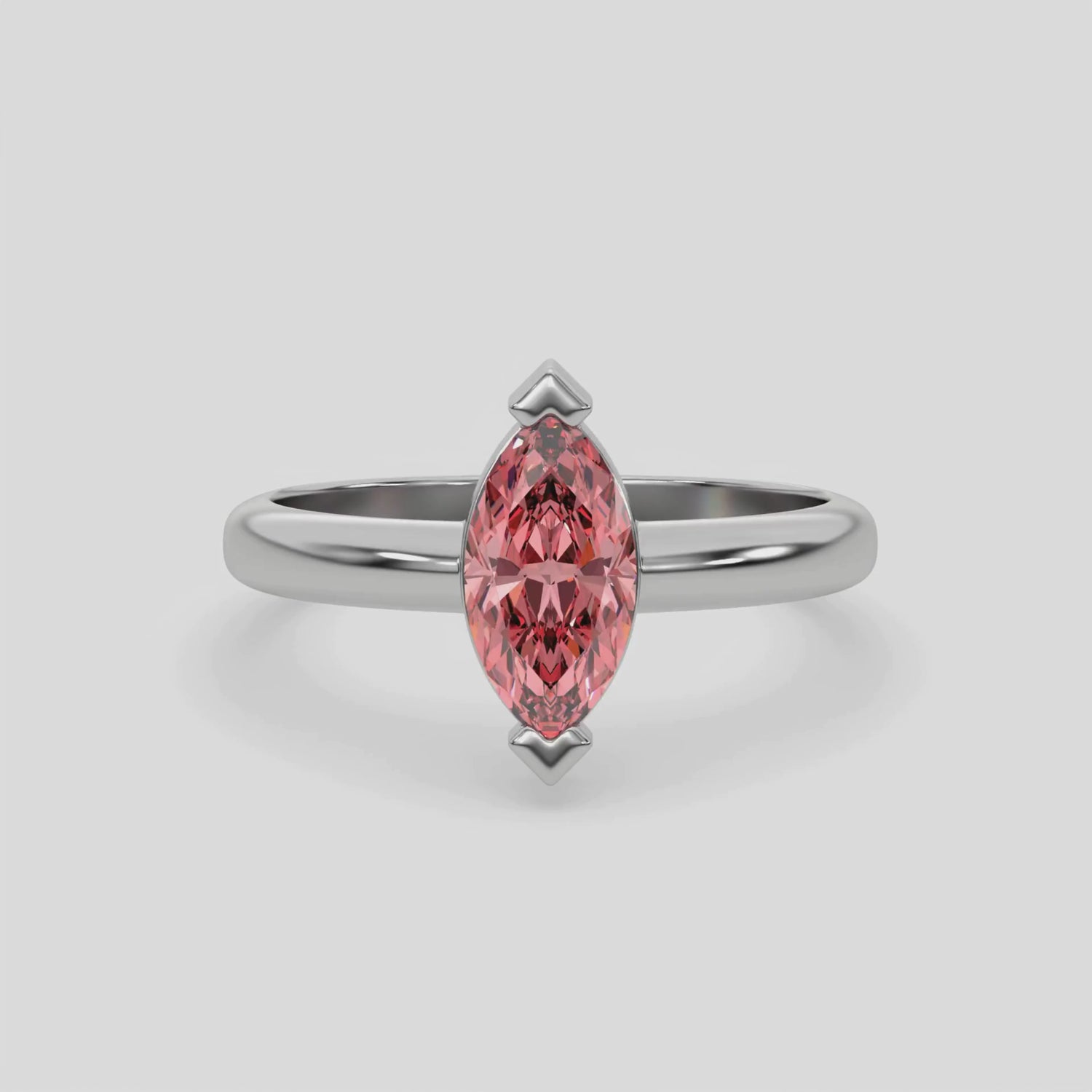 This video features a white gold ring features a fancy Pink marquise solitaire diamond elegantly secured in a two v-prong setting on a solid gold band