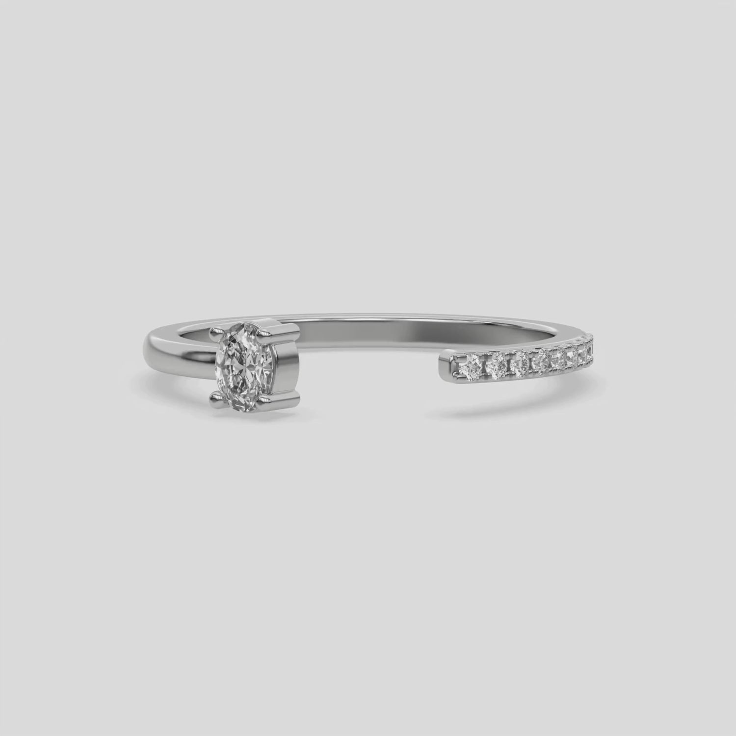 This video features a white gold Open Oval Diamond ring features an open gap in the center. One side with a 0.15 CT oval solitaire in a four prong setting, while the other side sparkles with 9 round brilliant-cut diamonds set in a micro-pave setting