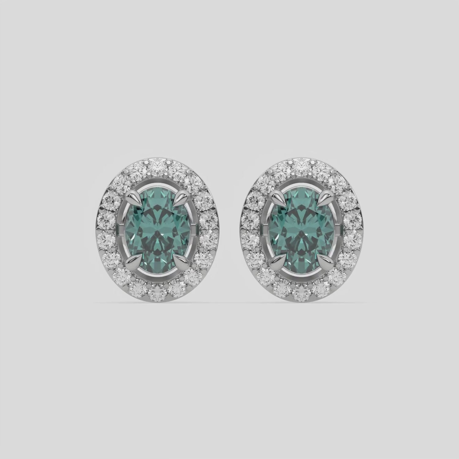 This video features a white gold Classic Oval Diamond Halo Earrings made with an fancy green oval cut solitaire diamonds set in a four prong setting