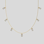 Oval Dangling Diamond Necklace made with seven oval cut diamonds each set in a prong setting, distributed evenly along the chain