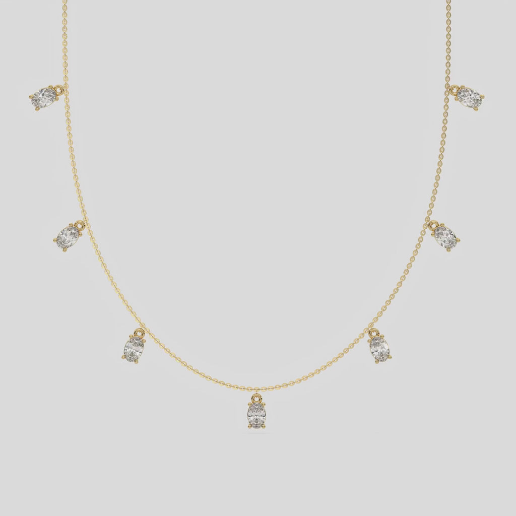 Oval Dangling Diamond Necklace made with seven oval cut diamonds each set in a prong setting, distributed evenly along the chain