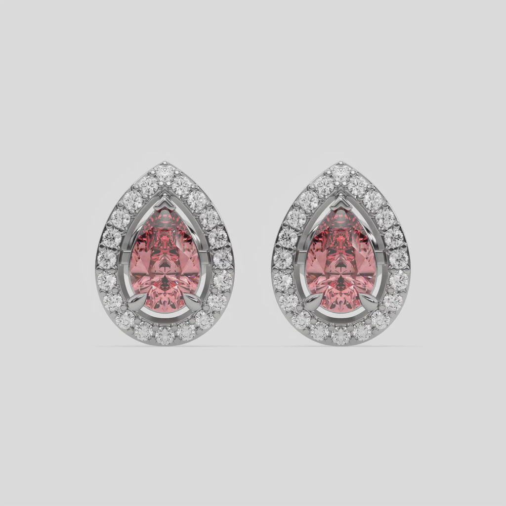 This video features a white gold Classic Pear Diamond Halo Earrings made with a fancy pink pear cut solitaire diamonds set in a four prong setting