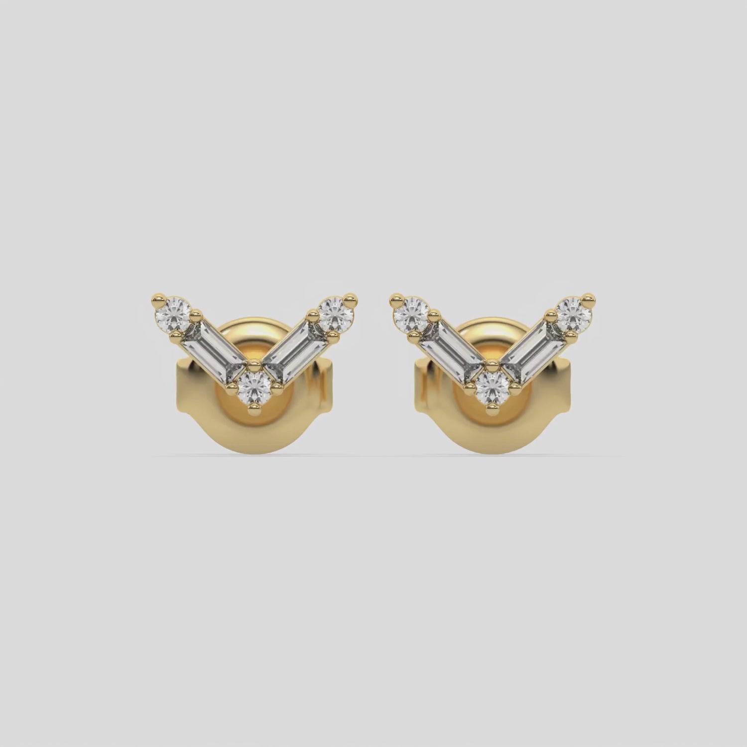 This video features a yellow gold Chevron Diamond Earrings made using baguette and round diamonds creating a v shaped design, securely set in shared prong setting