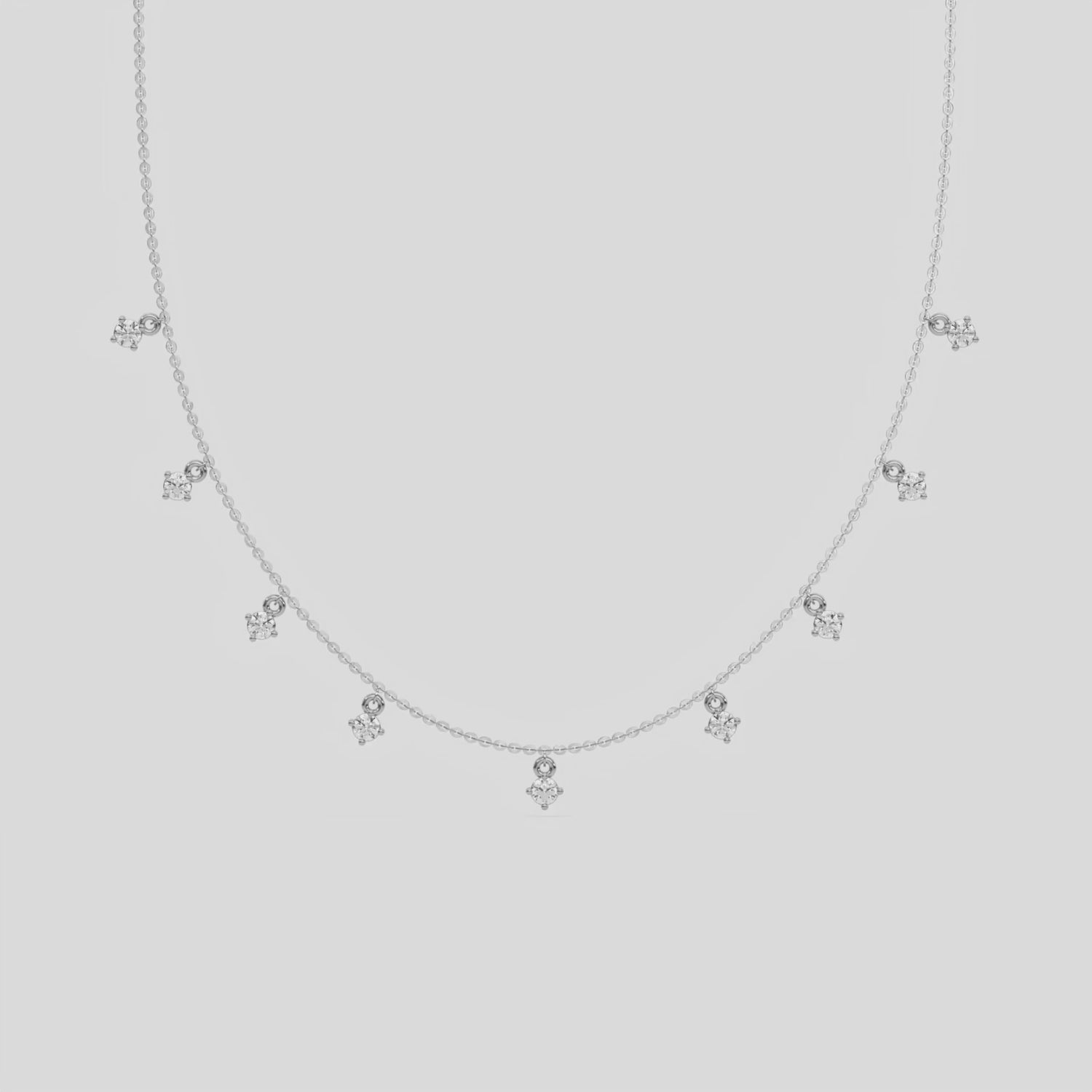 This yellow gold Round Dangling Diamond Necklace made with nine round brilliant-cut diamond set in a prong setting, distributed evenly along the chain