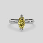 This video features a white gold ring features a fancy Yellow marquise solitaire diamond elegantly secured in a two v-prong setting on a solid gold band