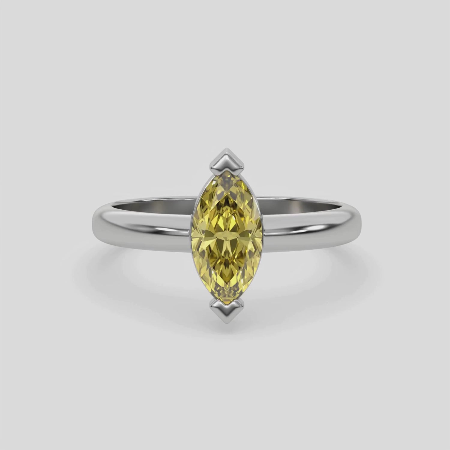 This video features a white gold ring features a fancy Yellow marquise solitaire diamond elegantly secured in a two v-prong setting on a solid gold band