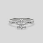 This video features a white gold ring features an oval solitaire diamond elegantly secured in a four-prong setting on a solid gold band 