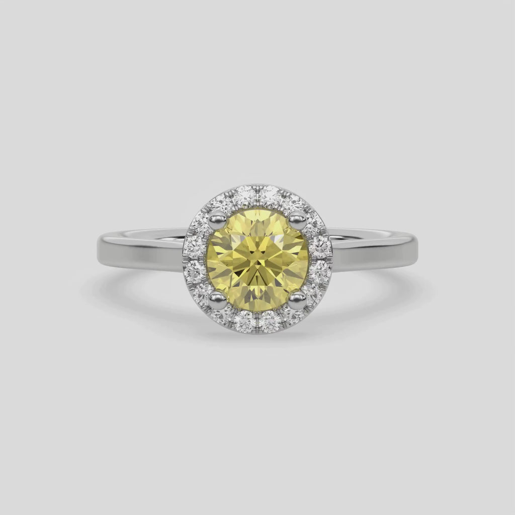 This video features a white gold ring features a fancy Yellow round solitaire diamond set in a four-prong setting