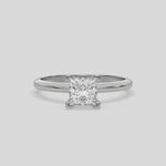 This video features a white gold ring features a princess solitaire diamond elegantly secured in a four-prong setting on a solid gold band 