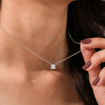 Close-up of an elegant yellow gold princess Diamond necklace with a square bezel-set diamond on a fine chain.