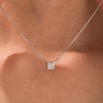 Close-up of an elegant white gold princess Diamond necklace with a square bezel-set diamond on a fine chain.