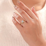 10K yellow gold round diamond solitaire engagement ring with a hidden halo curved band on a woman's hand